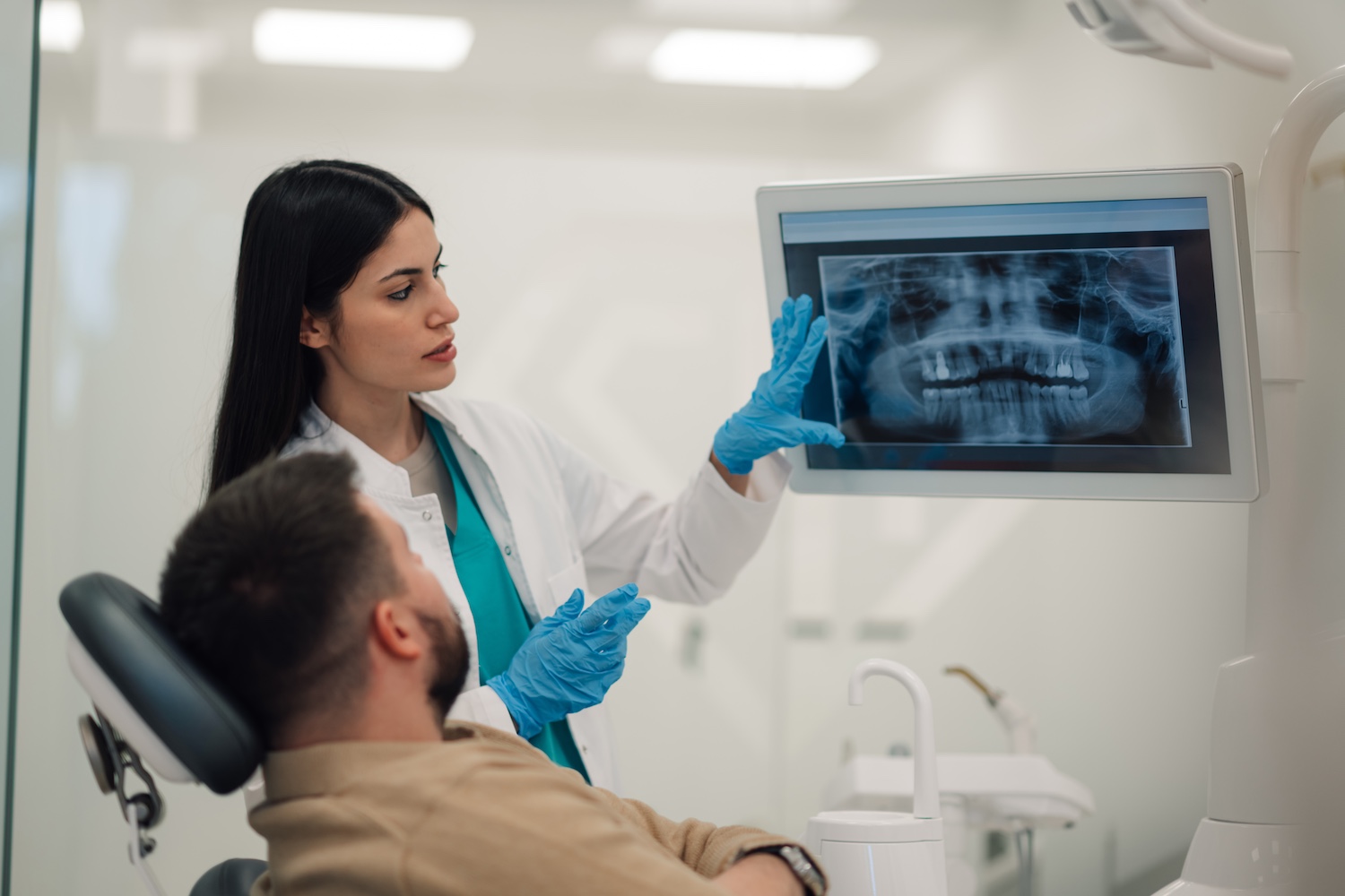 Dentist using Pearl AI modern dental technology to review digital X-rays for restorative dentistry diagnosis at The Foleck Center