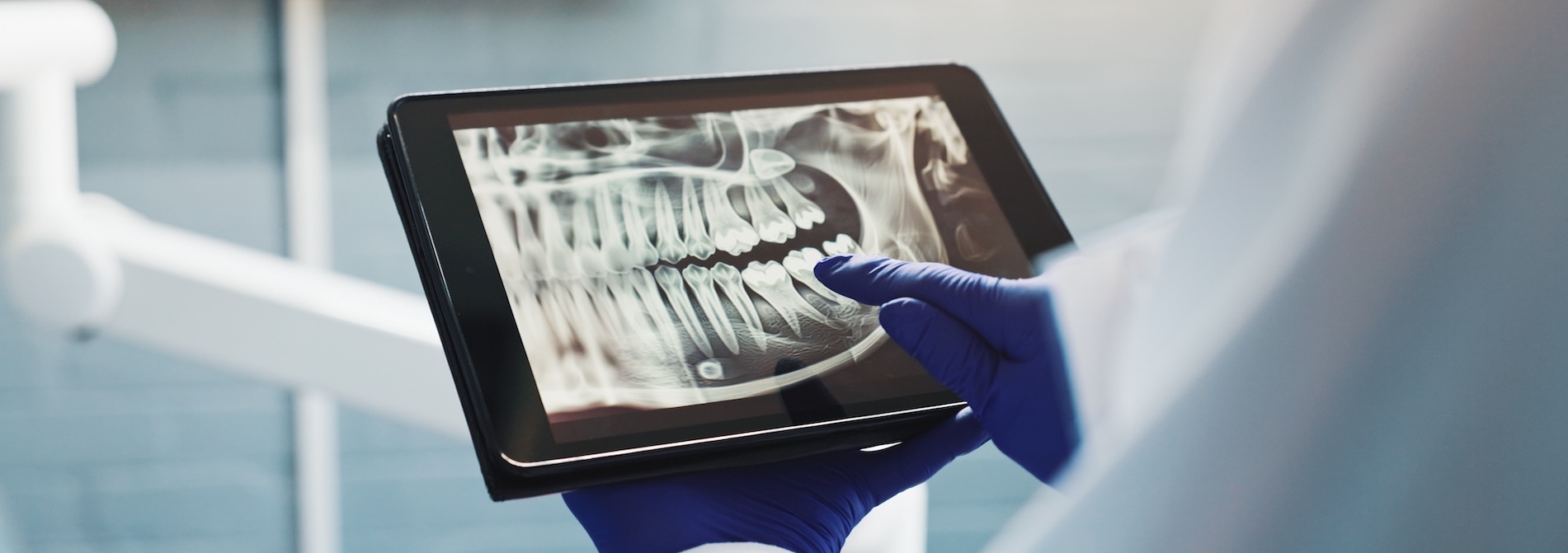 Hands, a dentist, and a tablet screen for X-ray, tooth diagnosis, or planning for healthcare treatment. Person, check, and dental surgeon with digital tech for teeth structure and orthodontic procedure.
