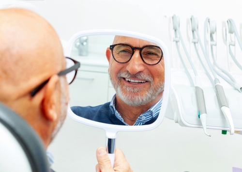 Dental patient smiling after dental implant surgery and following treatment plan in the implant recovery timeline