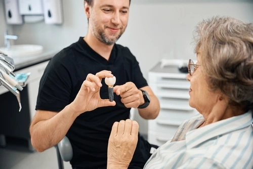 A dentist showing dental implants to a senior woman